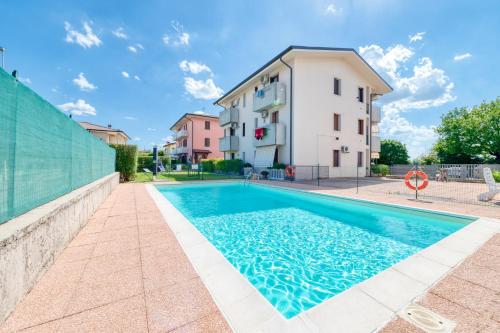 a swimming pool in front of a building at Wolf House - Sirmione Holiday in Sirmione