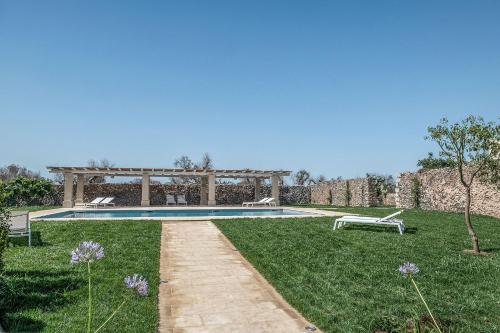 a park bench in front of a lush green field at Masseria Berzario in Melendugno