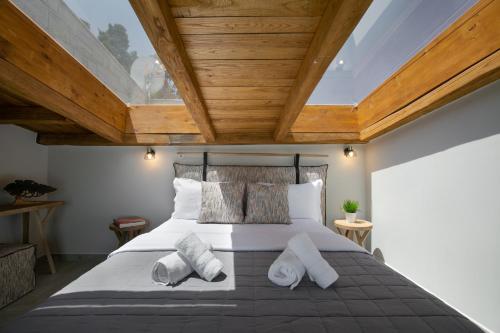 a bedroom with a large bed with wooden ceilings at The Euphoria Club Luxury Villas in Pefkochori