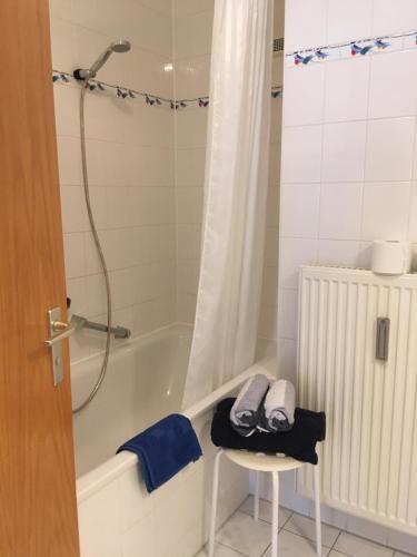 ein Bad mit einer Badewanne, einem Stuhl und einer Dusche in der Unterkunft Ferienwohnung-Ludwigsburg-City in Ludwigsburg