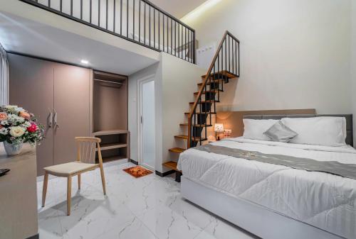 een slaapkamer met een groot bed en een trap bij Tree Homestay Mitra RedDoorz in Kasri