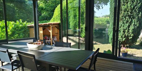 - une salle à manger avec une table, des chaises et de grandes fenêtres dans l'établissement Château Cantelaube, à Saint-Émilion