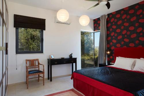 a bedroom with a bed and a desk and a chair at Villa The Longhouse- Pool-Sauna-Gym- Panormaic Seaview in Sellía