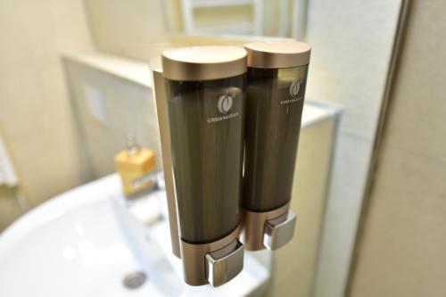 zwei schwarze und silberne Seifenspender auf einem Waschbecken in der Unterkunft FLH - House Angelique in Sibiu