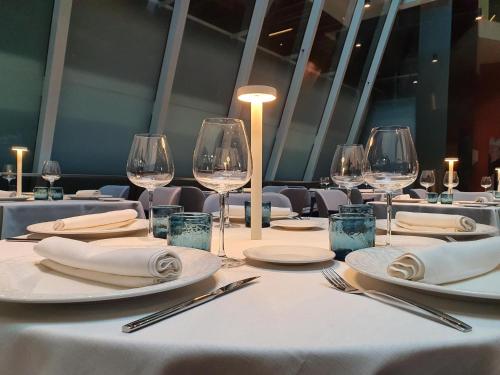 a table with white plates and wine glasses at Hotel Palacio La Marquesa 4 Estrellas SUP in Teruel