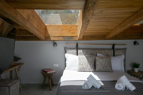 a bedroom with a bed with a wooden ceiling at The Euphoria Club Luxury Villas in Pefkochori