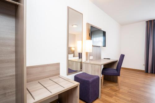 a room with a desk and a mirror and a chair at Bamberg Inn in Hallstadt