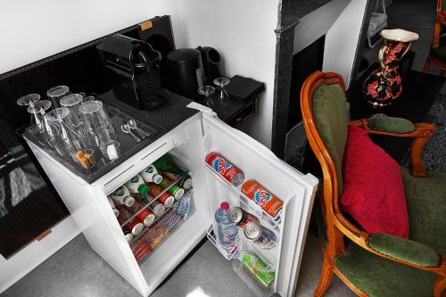 a small refrigerator with its door open next to a chair at LE CHERCHE MIDI Chambres d'hôtes avec CUISINE EQUIPEE grand jardin PARKING SECURISE GRATUIT in Albi