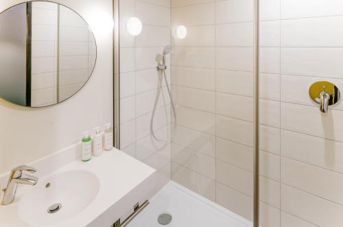a white bathroom with a shower and a sink at ibis Styles Paris Meteor Avenue d'Italie in Paris