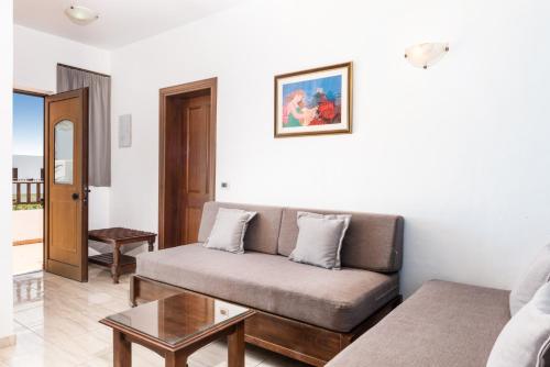 a living room with a couch and a table at Geraniotis Hotel and Resort in Plataniás