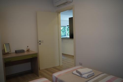 a bedroom with a bed and a desk and a window at San Martino Lake View Apartment in Ispra