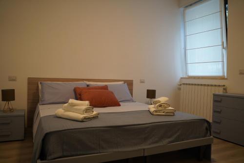 1 dormitorio con 1 cama con toallas en San Martino Lake View Apartment en Ispra