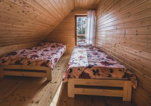 a bedroom with two beds in a log cabin at Kaszuby wczasy u Danusi sauna i bania in Lipusz