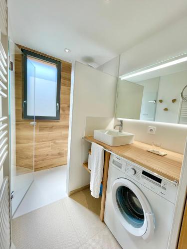 - une buanderie avec un lave-linge et un évier dans l'établissement 300 m Plage et Centre Ville - Parking Privatif et Gratuit sur Place - Terrasse Bois, à Larmor-Plage