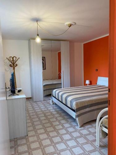 a bedroom with a bed with an orange wall at Domus Anxur in Terracina