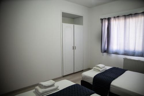 a small room with two beds and a window at Olive Island in Larnaka