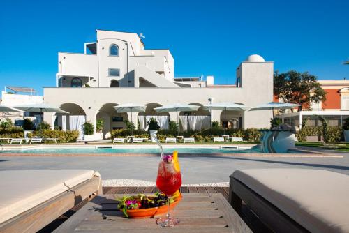 a drink sitting on a table in front of a pool at Insula Boutique Hotel in Procida