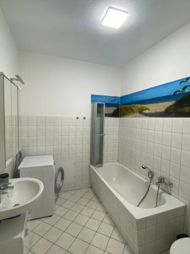 a bathroom with a tub and a toilet and a sink at Ferienwohnung H&M Immobilien Alsleben 1 in Alsleben