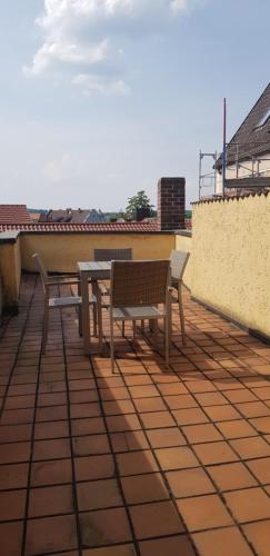 a patio with two benches and a table on a roof at Boardinghouse Marktplatz in Schwandorf in Bayern