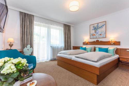 um quarto de hotel com uma cama e uma cadeira em Pension Pinzgauer Hof em Maria Alm am Steinernen Meer