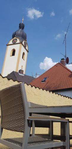 a bench in front of a building with a clock tower at Boardinghouse Marktplatz in Schwandorf in Bayern