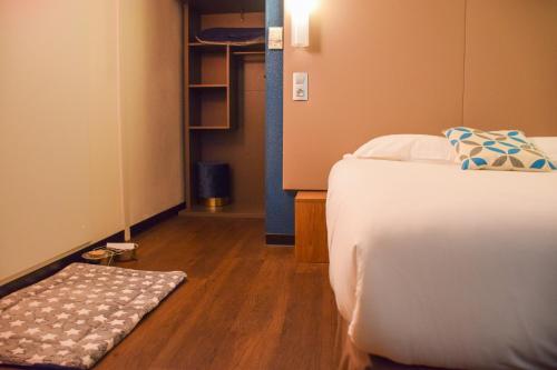 a bedroom with a bed and a wooden floor at Campanile Millau in Millau