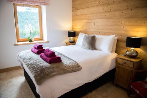 - une chambre avec un grand lit et des serviettes pourpres dans l'établissement 'Petite Ferme Les Bouts' Apartment, sleeps 6, Nr Morzine, à La Côte dʼArbroz
