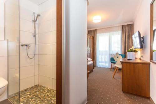 La salle de bains est pourvue d'une douche et d'un lavabo. dans l'établissement Pension Pinzgauer Hof, à Maria Alm