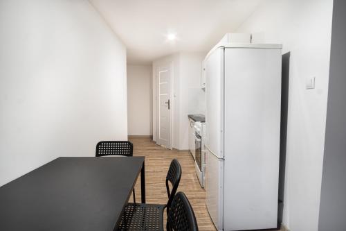 a kitchen with a table and chairs and a refrigerator at Revolution Aparts - Rewolucji 27 in Łódź