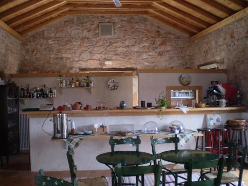 cocina con mesa, sillas y barra en Arachovitika Kalivia, en Karyes