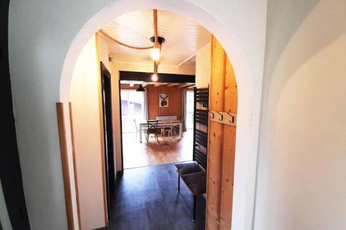 an archway leading into a dining room with a table at Chalet de Xonrupt / Vue splendide sur les montagnes in Xonrupt-Longemer