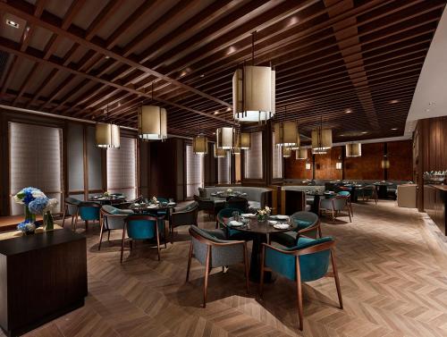 a dining room with tables and chairs and chandeliers at Hyatt Regency Shanghai Songjiang in Songjiang