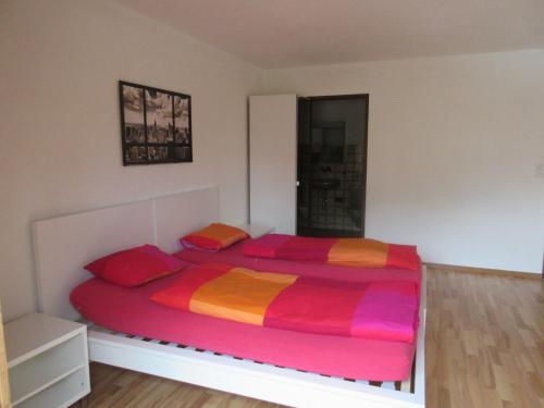 a bedroom with a large bed with colorful sheets at good bed Aarwangen in Aarwangen