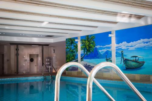 a swimming pool with a mural of a boat at Hotel Park Soltau in Soltau