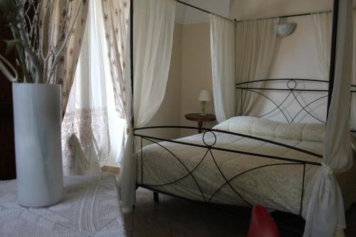 a bedroom with a bed and a vase at Hotel Porta Santa Maria in Busca
