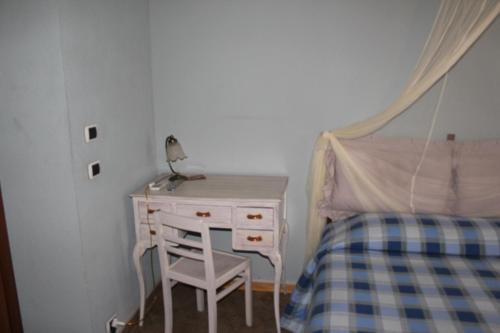 a small bedroom with a desk and a bed at Hotel Porta Santa Maria in Busca