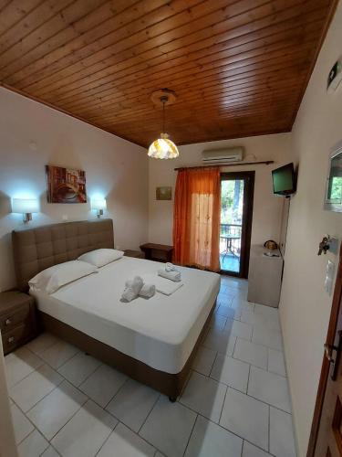 a bedroom with a large bed with a wooden ceiling at Mavra Studios in Lygia