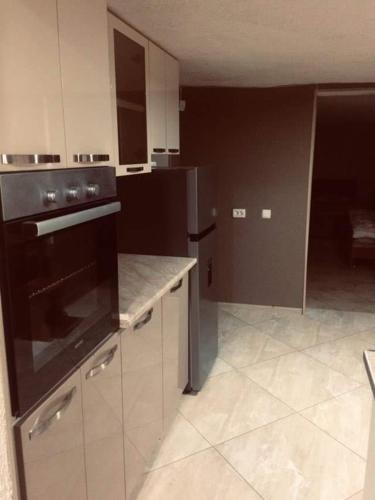 a kitchen with a stove and a counter top at Guesthouse Raisa in Kvareli