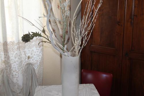 a white vase sitting on top of a table at Hotel Porta Santa Maria in Busca