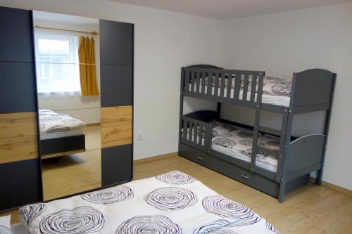 een kamer met 2 stapelbedden en een spiegel bij Apartmány pod Soláněm in Karolinka