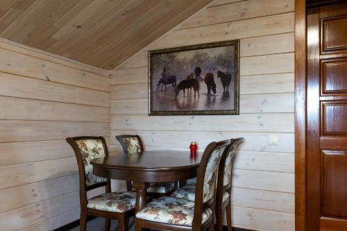 a dining room with a wooden table and chairs at Гостиница Олимп-парк in Belokurikha