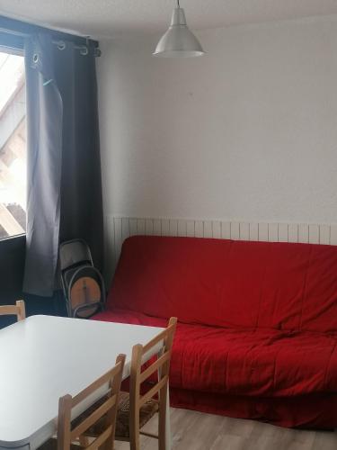 un salon avec un canapé rouge et une table dans l'établissement résidence campbielh 1, à Aragnouet
