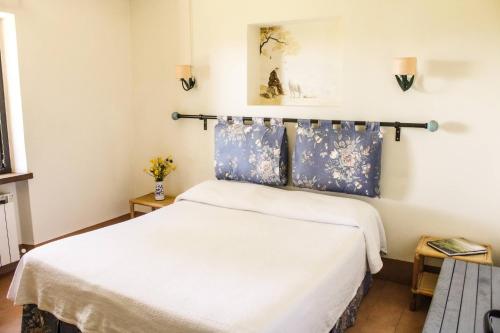 um quarto com uma cama com lençóis azuis e brancos em Poggio alle Vigne em Torgiano