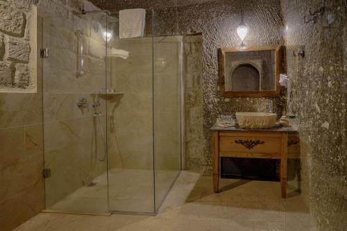 a bathroom with a glass shower and a sink at Hera Cave Suites in Goreme