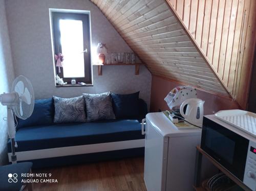 een woonkamer met een blauwe bank en een trap bij Tőserdő in Lakitelek