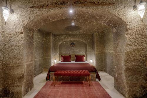 a bedroom with a bed in a stone room at Hera Cave Suites in Goreme