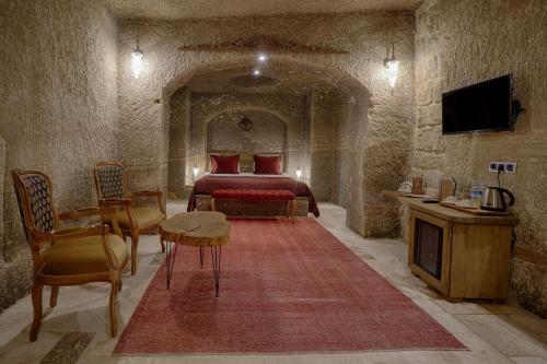 a bedroom with a bed and a table and chairs at Hera Cave Suites in Goreme
