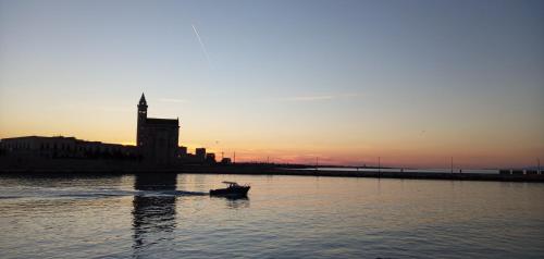 a boat in the water with the sunset in the background at Bed and Breakfast il Pesciolino in Trani