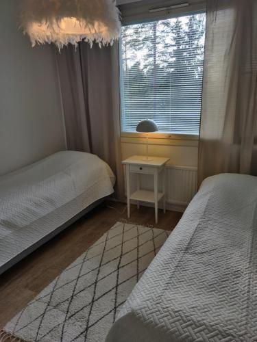 um pequeno quarto com 2 camas e uma janela em Yyterin valkoinen huoneisto 14A talo B 21 em Pori