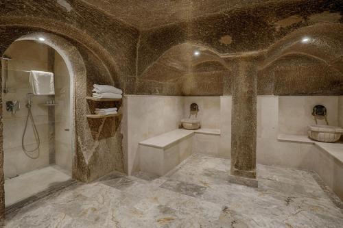 a bathroom with a shower and a tub and a sink at Hera Cave Suites in Goreme